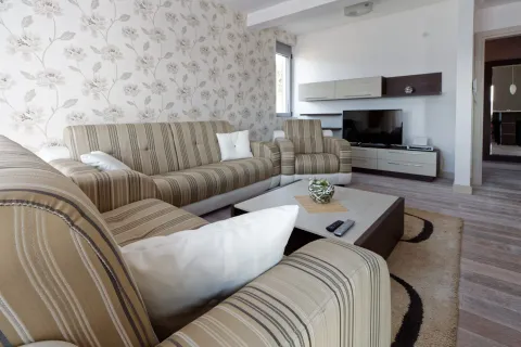 Uređena dnevna soba sa garniturom, stočićem i televizorom. - image 2