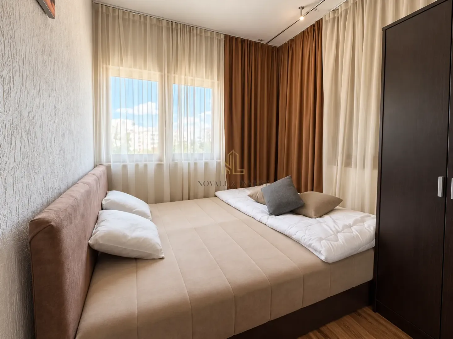 Furnished bedroom with a double bed, window, and wardrobe.