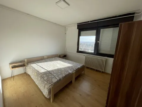 Bedroom with a double bed, nightstands, and a window overlooking the city. - image 6
