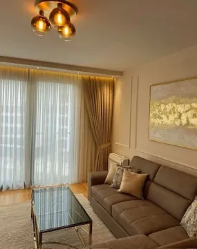 Living room with a sofa, coffee table, and modern lighting. - image 5