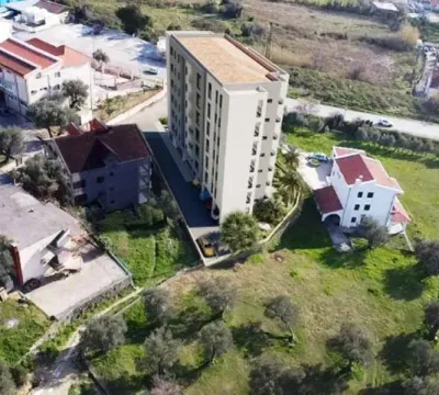 Pogled iz vazduha na stambenu zgradu i okolno naselje sa zelenilom. - image 6