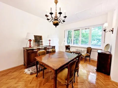 Dining room with a wooden table, chairs, and a chest of drawers. - image 10