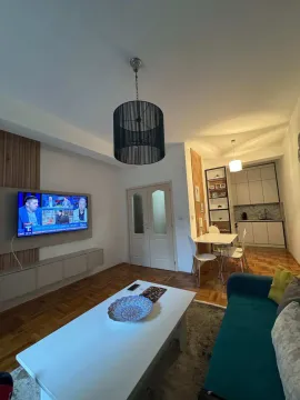 Dnevna soba sa garniturom i televizorom, povezana sa trpezarijom i kuhinjom. - image 9