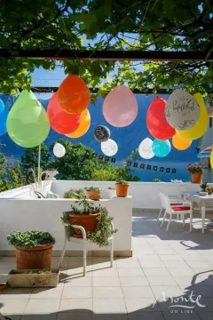Namještena terasa ukrašena balonima sa pogledom na more. - image 26