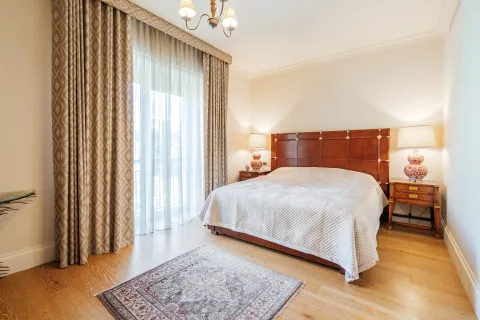 Prostrana spavaća soba sa velikim bračnim krevetom, noćnim stočićima i balkonskim vratima. - image 9