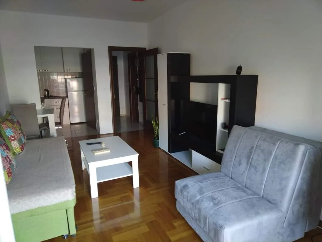Furnished living room with seating and a view of the kitchen.