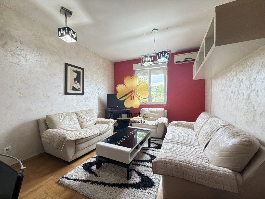Living room with a sofa set, coffee table, and a red accent wall.