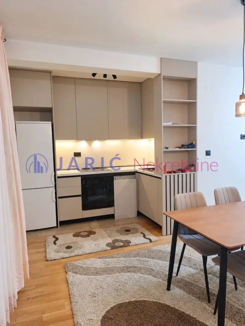 Modern kitchen with built-in units and a dining table.