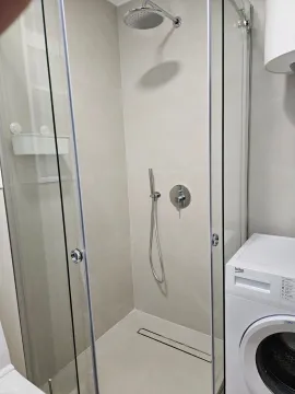 Moderno opremljeno kupatilo sa tuš kabinom i veš mašinom. - image 7