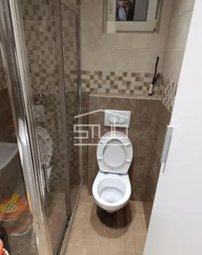 Manje kupatilo sa tuš kabinom i WC šoljom u popločanom prostoru. - image 8