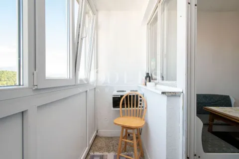 Enclosed balcony with a chair and a small stove. - image 9