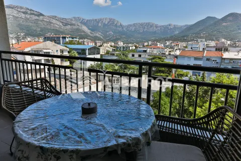 Namješten balkon sa stolom i stolicama i pogledom na grad i planine. - image 14