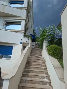 Spoljni dio zgrade sa stepeništem i uređenim zelenilom. - image 16