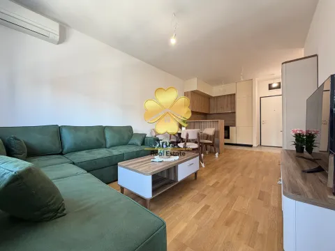 Living room with a sofa and a view of the dining area and kitchen. - image 3