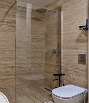 Moderne kupatilo sa tuš kabinom i ugradnom šoljom obloženo keramičkim pločicama. - image 14