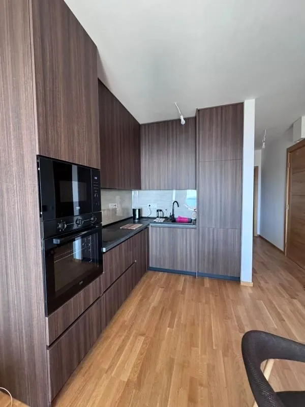 Modern kitchen with dark wood cabinetry and a built-in oven.