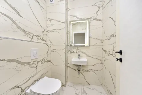 Small bathroom with light marble tiles, a washbasin, and a wall-hung toilet. - image 18