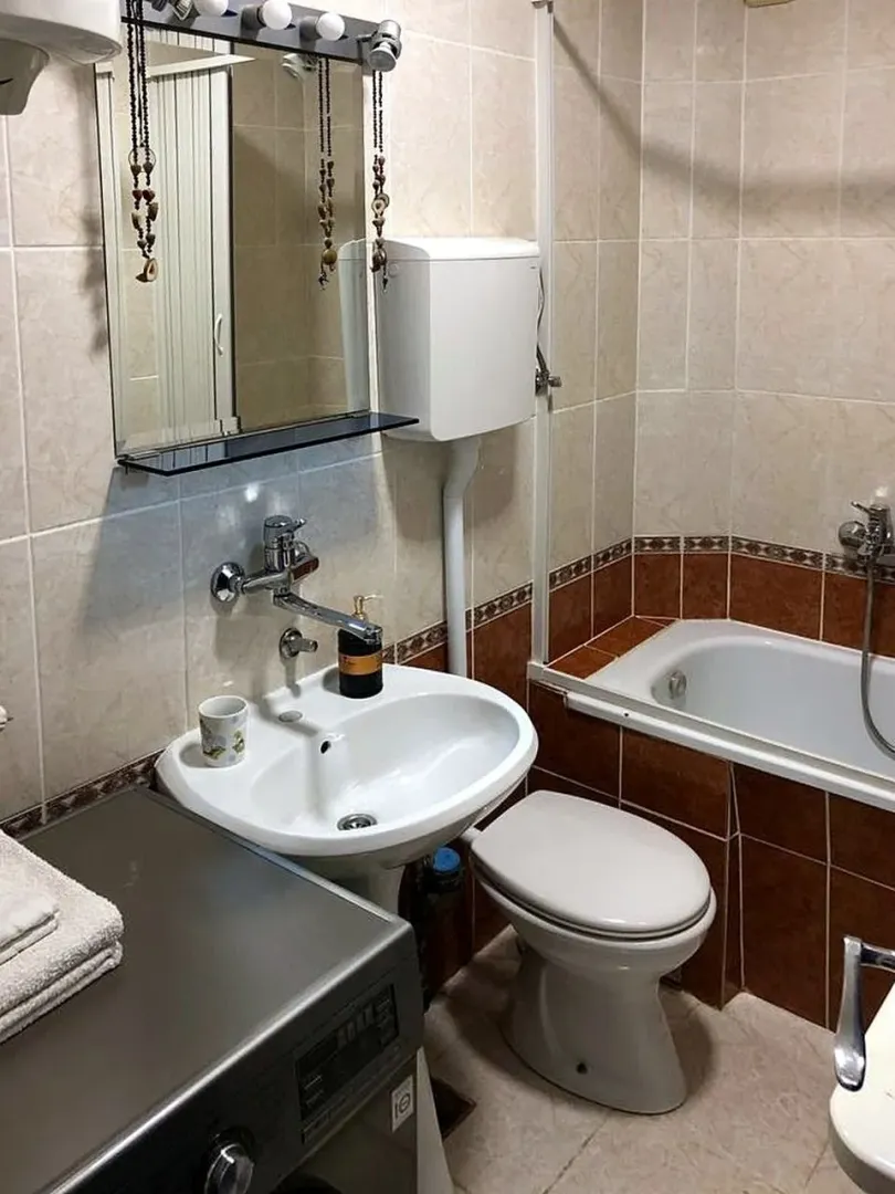 Bathroom equipped with a washbasin, toilet, bathtub, and washing machine.