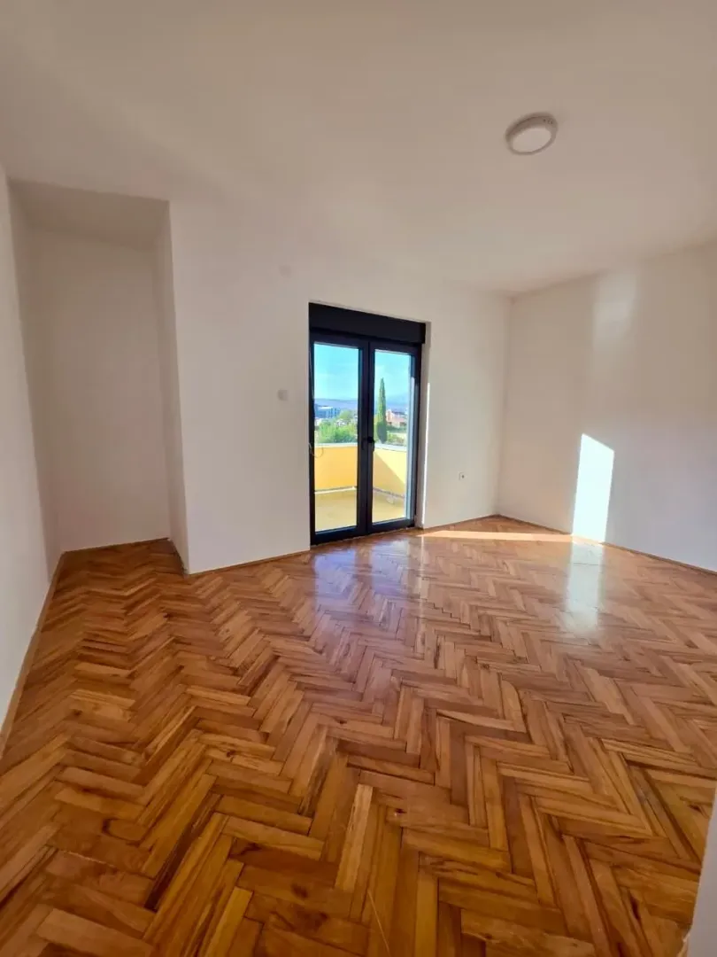 Empty room with parquet flooring and access to the terrace.