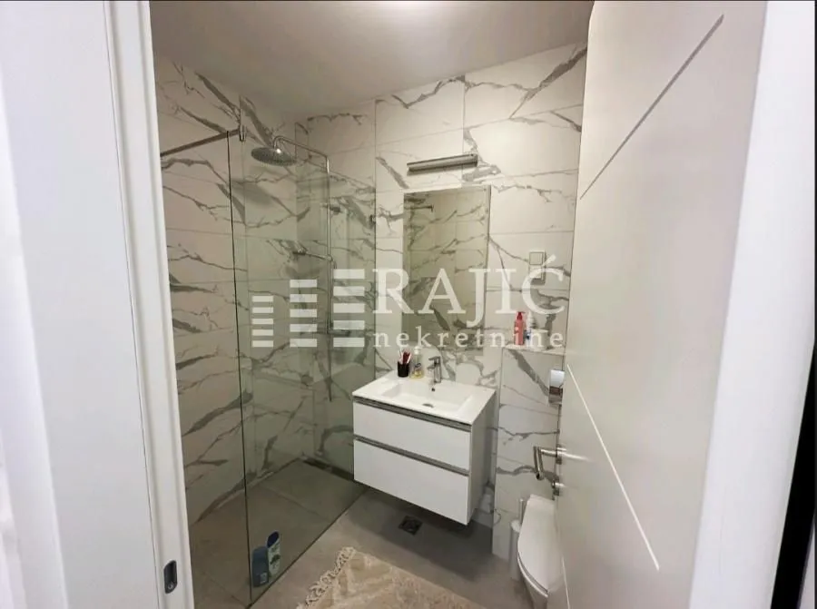 Modern bathroom with a walk-in shower and a vanity unit.