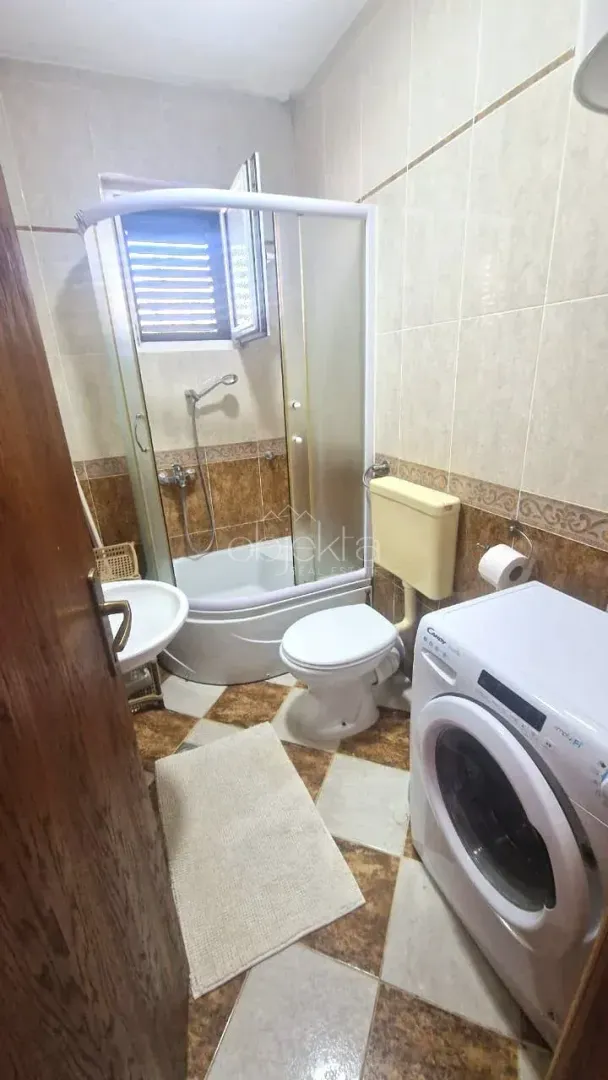 Kupatilo opremljeno tuš kabinom, toaletom, umivaonikom i veš mašinom.