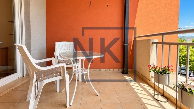 Furnished terrace with a table, chairs, and potted flowers.