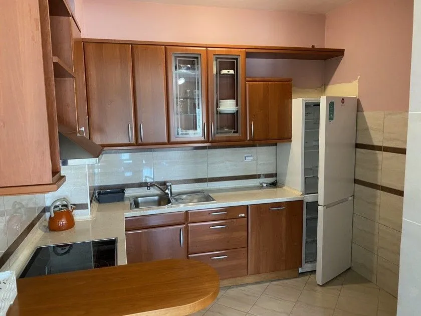 Kitchen with wooden cabinets and a refrigerator.