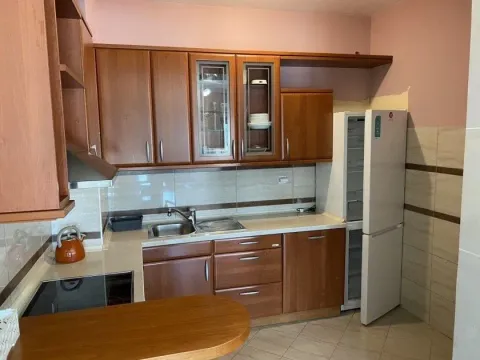 Kitchen with wooden cabinets and a refrigerator. - image 4
