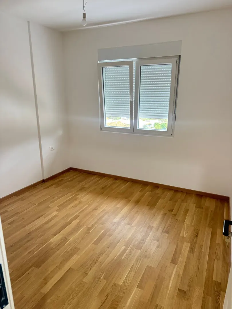 Empty room with parquet flooring and white walls.
