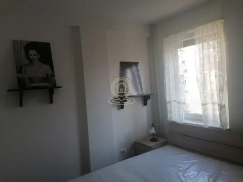 Spavaća soba sa krevetom, noćnim stočićem i prozorom. - image 6