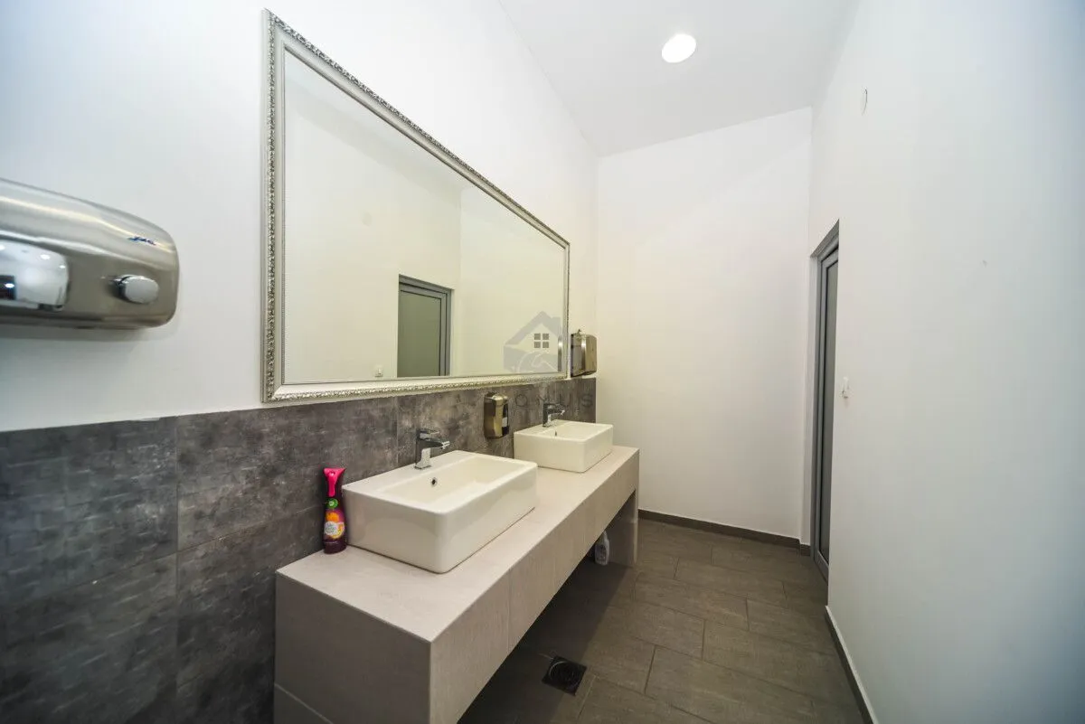 Modern bathroom equipped with two washbasins and a large mirror.
