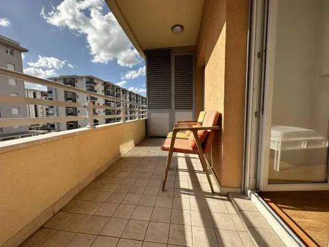 Natkrivena terasa sa stolicama i pogledom na okolne zgrade. - image 21