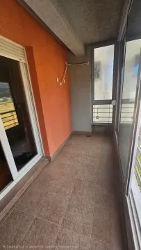 Zastakljeni balkon sa keramičkim pločicama i narandžastim zidom. - image 10