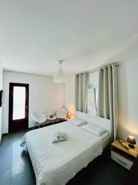 Bright and tidy bedroom with a double bed, white furniture, and terrace access. - image 7