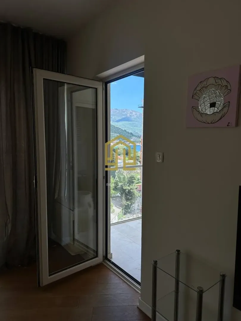 Pogled na terasu i okolinu kroz otvorena balkonska vrata.