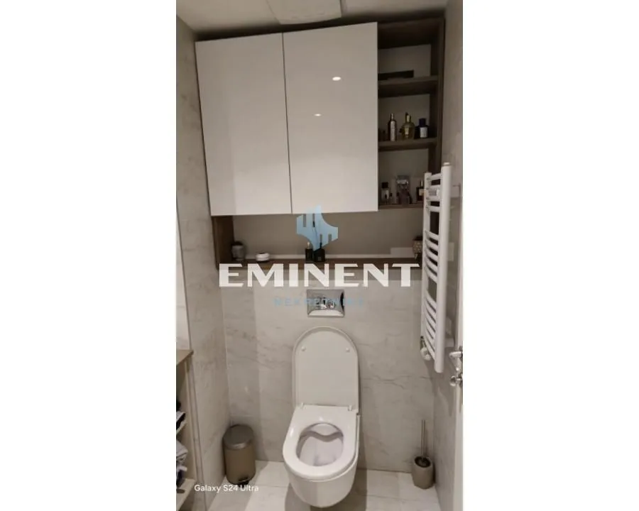 Modernly equipped bathroom with a wall-hung toilet and hanging cabinet.
