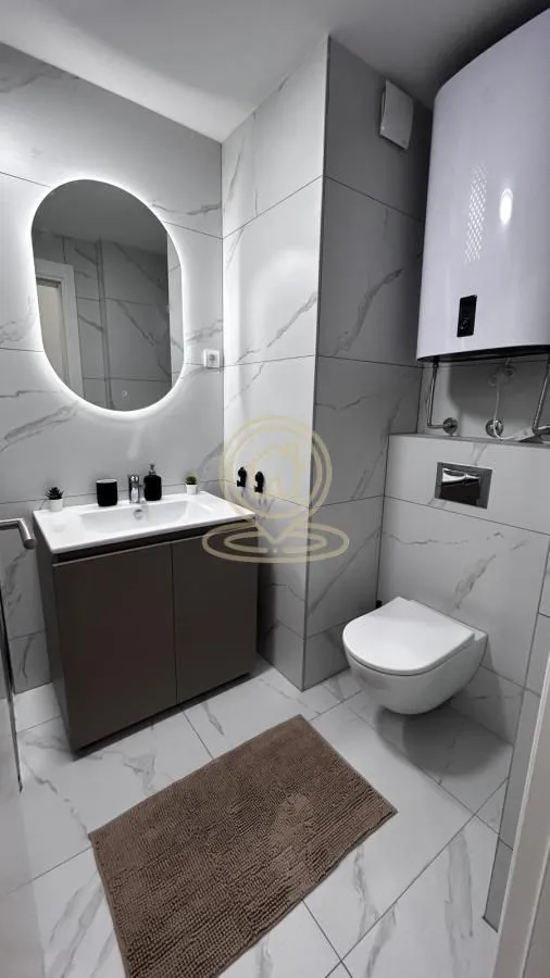 Modernly equipped bathroom with a washbasin, mirror, and wall-hung toilet.