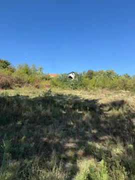 Pogled na plac sa travnatom površinom i zelenilom u pozadini. - image 6