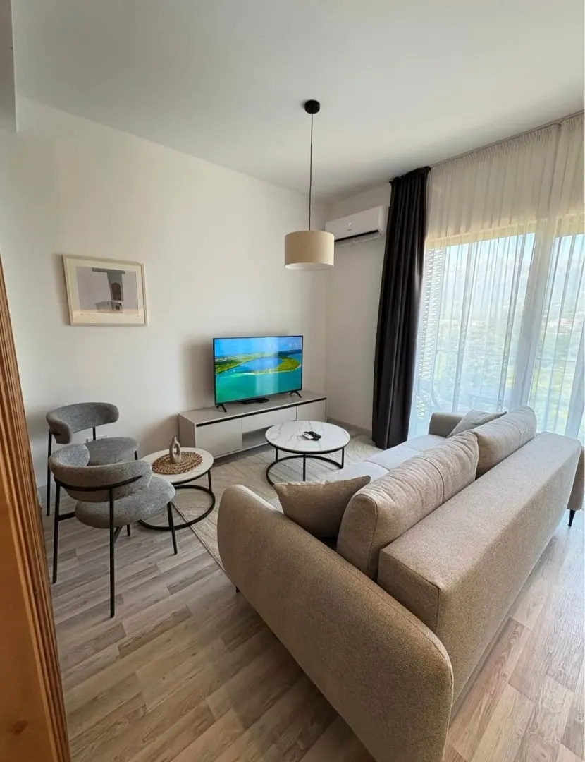 Bright living room with a sofa, coffee table, and television.