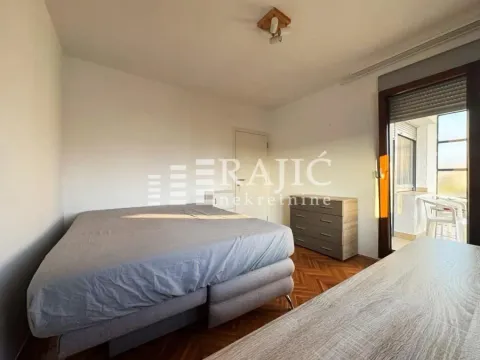A bedroom with a double bed, dresser, and balcony access. - image 5