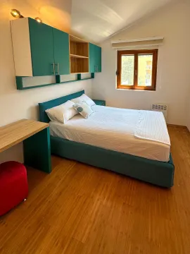 Namještena spavaća soba sa bračnim krevetom, plavim visećim elementima i prozorom. - image 4