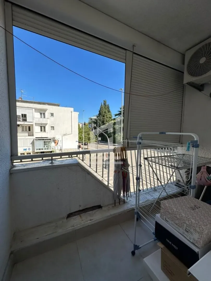 Natkriveni balkon sa stalkom za sušenje veša i pogledom na ulicu.