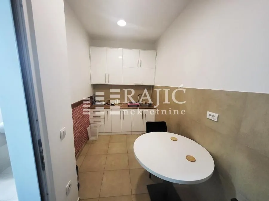 Smaller kitchen with a dining table and white cabinets.