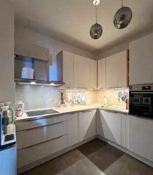 Modern kitchen with built-in appliances and under-cabinet lighting. - image 8