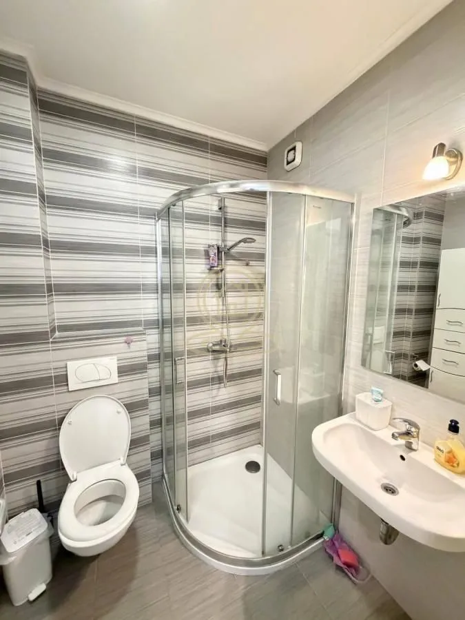 Kupatilo opremljeno tuš kabinom, umivaonikom i WC šoljom.