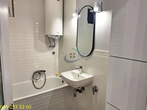 Smaller bathroom with a bathtub, washbasin, and water heater. - image 8