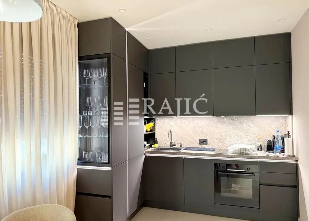 Modern kitchen with dark cabinets and built-in appliances.