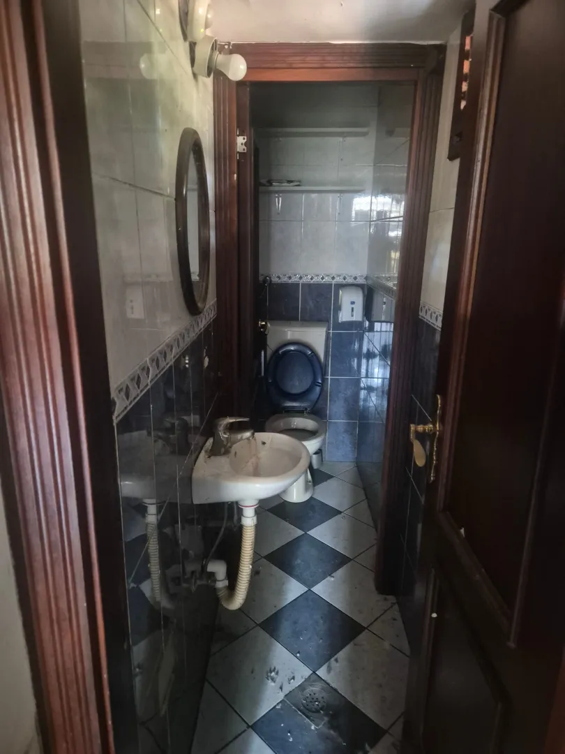 Older bathroom with a washbasin and toilet.