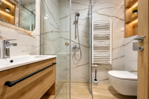 Modern bathroom equipped with a walk-in shower, vanity unit, and wall-hung toilet. - image 14