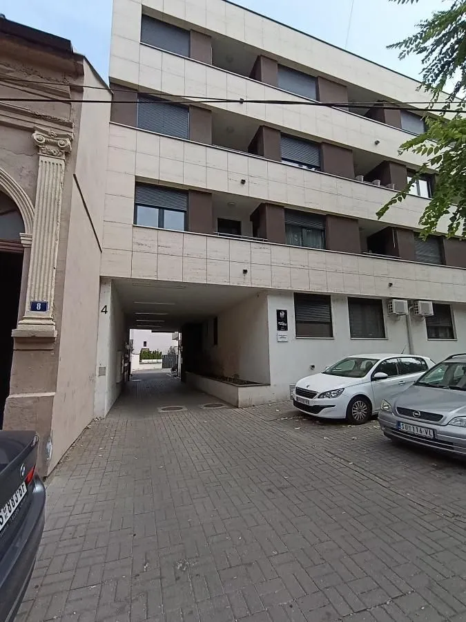 Exterior view of the residential building with a passageway and parking.